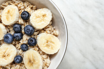 Bowl with tasty sweet oatmeal, closeup
