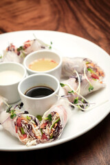 asian fresh vegetable vegan spring rolls with sauces in vietnam