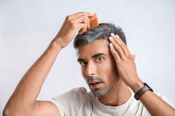 Stressed man with graying hair on light background