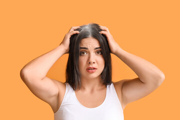 Stressed woman with graying hair on color background