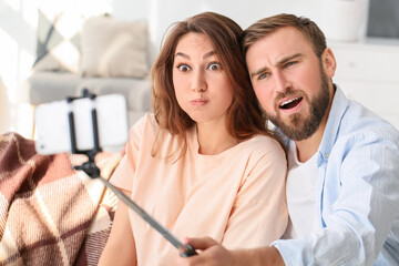 Fototapeta premium Young couple taking selfie at home