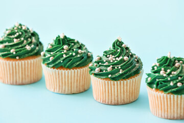 Tasty Christmas cupcakes on color background