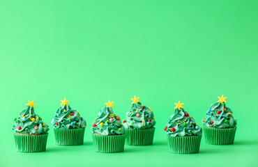 Tasty Christmas cupcakes on color background