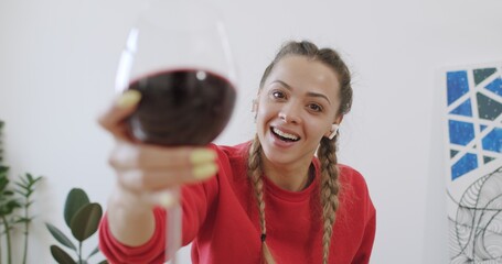 Woman having glass of wine while chatting with friend