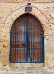 Wooden door and arch of the church facade of the abandoned village of Otero de Sariegos, Villafáfila, Zamora, Spain.