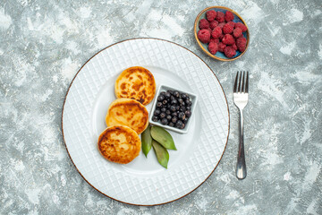 top view sweet muffins with berries inside plate on a light background taste fruit photo pancake sugar dough