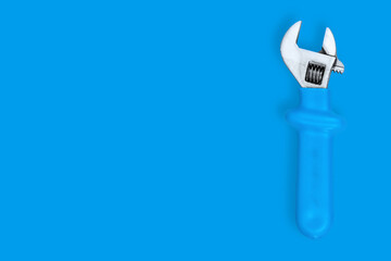 Wrench on a blue background. Seamless background from adjustable metal wrench.