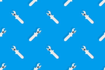 Wrench on a blue background. Seamless background from adjustable metal wrench. Seamless patterns.