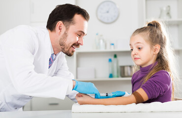 Obraz premium Glad doctor ready to make injection to teenage female visitor in hospital