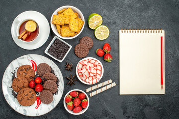 top view choco biscuits with candies and tea on dark desk sweet cookie photo