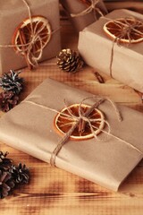 Gifts for Christmas and New Year. packed craft gifts with cinnamon and orange for decoration.