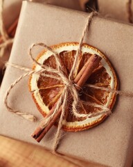 Gifts for Christmas and New Year. packed craft gifts with cinnamon and orange for decoration.