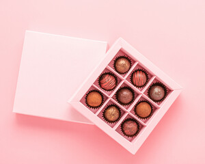 Chocolate truffle candies box pink background. Gifts festive food love concept