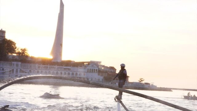 Mens are making tricks with flyboards at sunset. High quality 4k footage