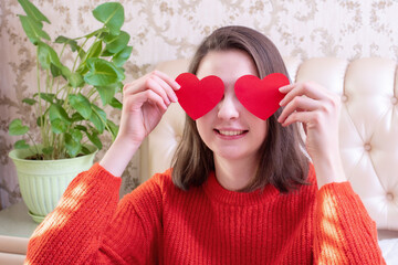 Happy Valentines Day. Beauty joyful smiling caucasian girl holding a valentine card in the shape of a heart in her hands at home. Love concept