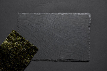 Black textured sushi slate board background with copyspace. Place for sushi, Japanese cuisine concept.