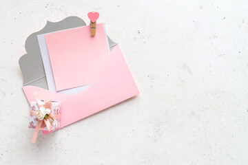 Pink envelope and gift box on white stone background. Love concept. Romantic congratulation Mockup on Valentine's Day.