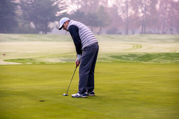 Obraz premium With a putt, hit the hole with the golf ball