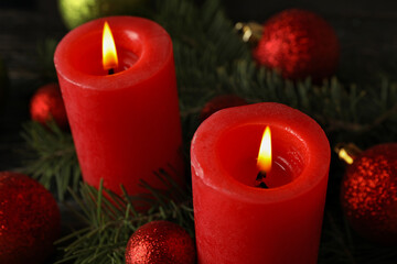 Red candles, baubles and pine branches, close up