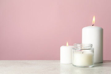 Scented candles for relax on white table against pink background