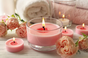 Pink scented candles on white wooden background