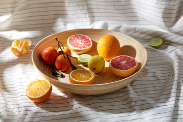 food, healthy eating and vegetarian concept - close up of citrus fruits on wooden plate