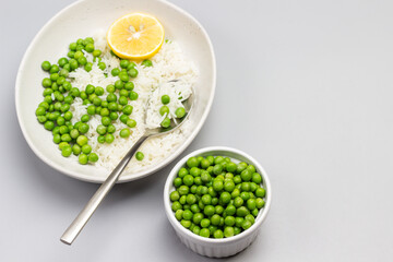 Boiled basmati rice with green peas in plate. Green peas in bowl