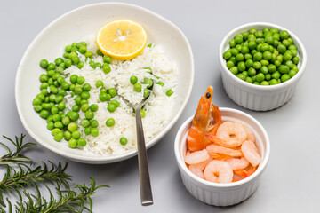 Boiled basmati rice with green peas in  plate. Shrimp and green peas in bowls