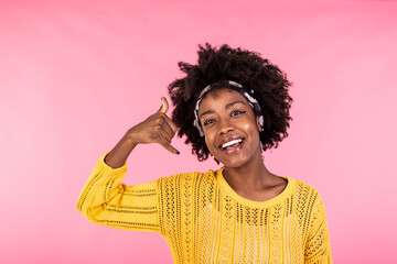 Fototapeta na wymiar Young beautiful woman doing talking on the telephone gesture and feeling happy. African american woman wearing casual clothes, smiling and looking at camera
