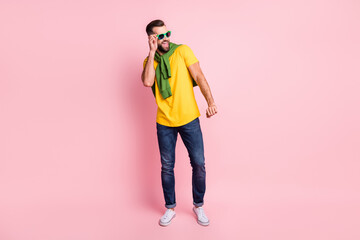 Full length photo of young man wear glasses dance jumper on shoulders isolated on pastel pink color...