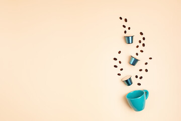 Top view of coffee capsules and cup over beige background with copy space. Morning dose of caffeine, energy, flavor concept