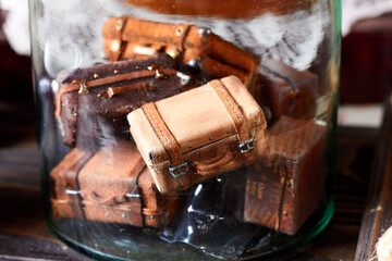 Glass jar with vintage toy suitcases. Interior decor details in old style. Close up