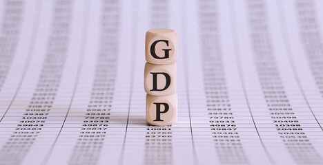 GDP word written on wood block on the chart background .