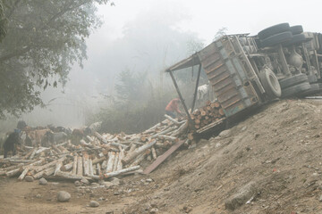 Fototapeta premium scene during foggy weather where wooden logs fallen from a accidented truck