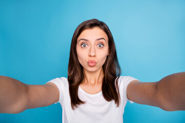 Fototapeta na wymiar Photo of young lovely cute sweet attractive beautiful girl taking selfie pout lips wear white t-shirt isolated on blue color background