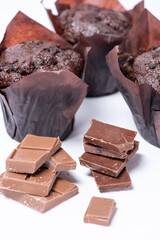 Delicious muffins with slices of chocolate isolated on white background