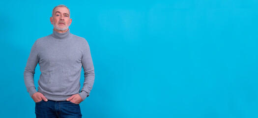 Confident middle-aged man in jeans and sweater