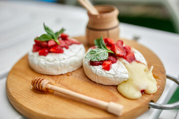 Grilled camembert cheese with strawberry, honey and basil leaves, delicatessen