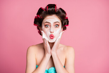 Close-up portrait of attractive amazed housewife applying mousse on face pout lips isolated on pink pastel color background