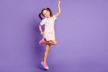Full size photo of funky happy nice girl raise fist jump air wear pink dress isolated on violet...