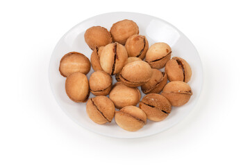 Cookies in shape of nuts with caramel filling on dish
