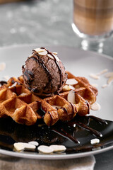 Viennese waffles with ice cream, chocolate and latte. Close-up. On the plate