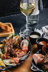 grilled seafood platter. Assorted delicious grilled seafood with vegetables. Grilled mixed bastards with pepper sauce and vegetables. Black background