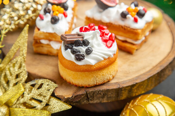 front view delicious cream cakes around new year tree toys on a dark background dessert cake sweet photo cream