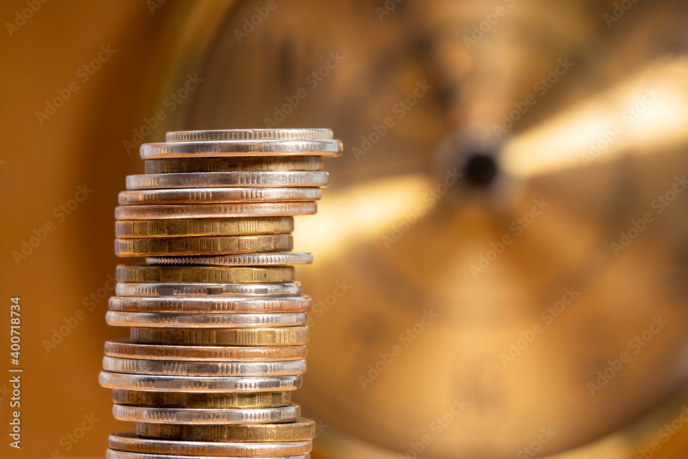Aufkleber stack of coins on the background of the clock. money time concept