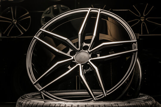 Sports Alloy Wheel Rim With Carbon Cover, In The Hall Of The Car Shop On The Background Of Wheels. Dark Background, Light Shining From Above