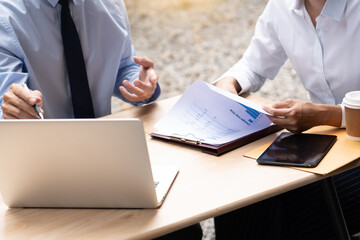 Two asian business coworkers outside office buildings discuss and commenting work to each other