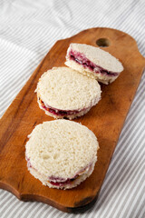 Homemade Crustless Peanut Butter  and Jelly Circles on a rustic wooden board, side view.