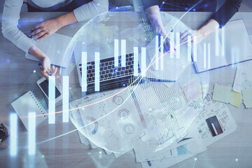 Double exposure of woman hands working on computer and forex graph hologram drawing. Top View. Financial analysis concept.