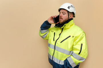 Male industrial worker with phone. Bearded engineer with white hard hat helmet. Climber